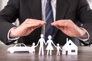 Concept of insurance Concept of insurance with hands over a house, a car and a family