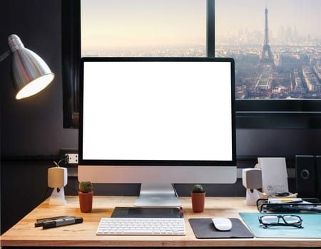 Graphic designer's workspace with cityscape view with a pen tablet, a computer and white background for text
